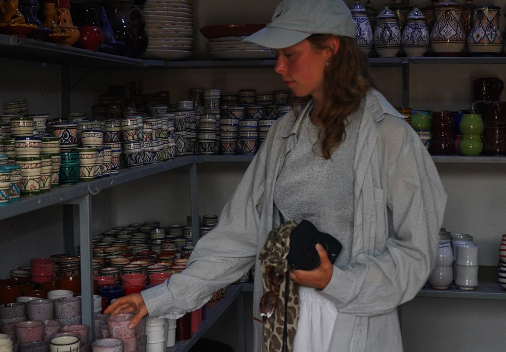 Guests exploring traditional Moroccan handmade cups at Nomad Surf Camp, Morocco. Cultural experience and local craftsmanship.
