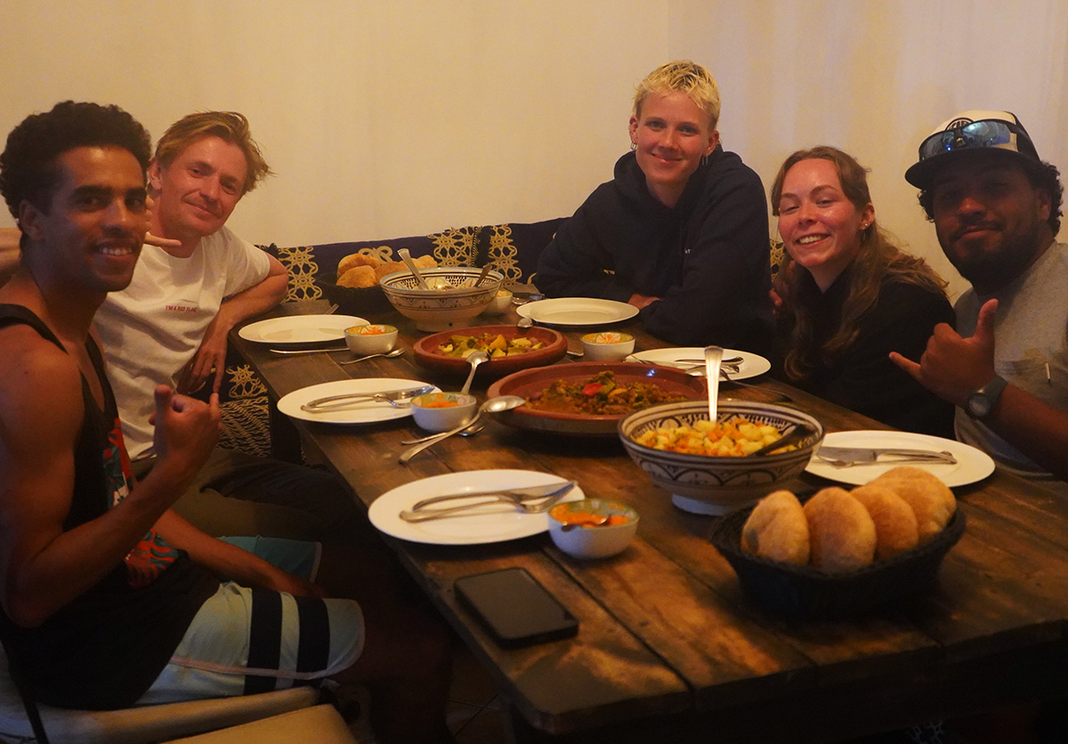 Group of guests enjoying dinner together in Morocco. Evening meal and social gathering at Nomad Surf Camp
