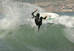 Surfer performing a stylish flip on a big wave at Taghazout, Morocco. Action-packed surfing at Nomad Surf Camp