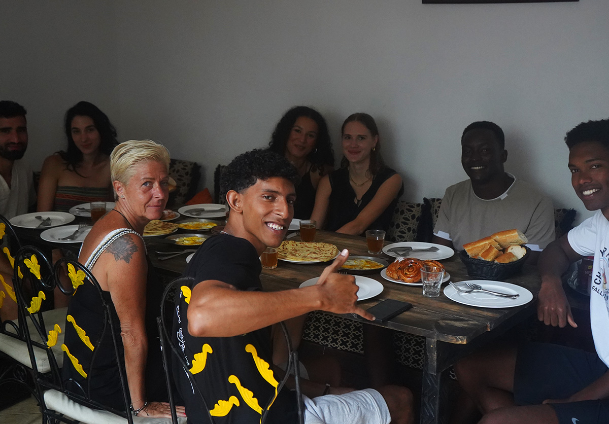 Guests from around the world enjoying breakfast together at Nomad Surf Camp, Morocco. Multicultural surf camp experience
