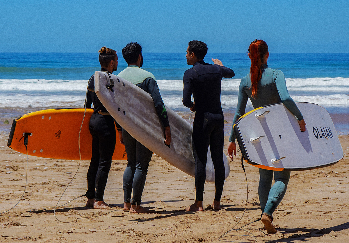 Surf instructor explaining different types of waves to students at Nomad Surf Camp in Tamraght, Morocco